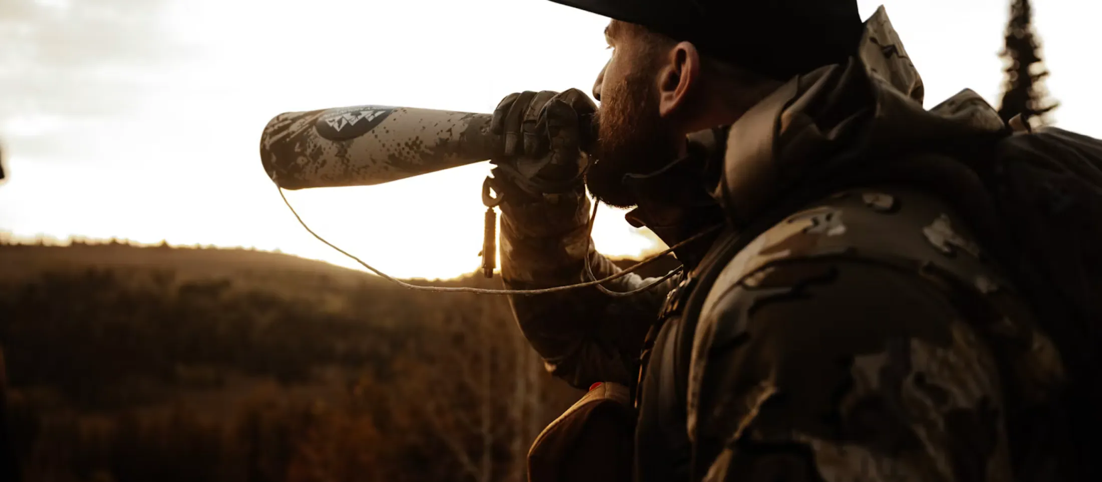A hunter calling from a ridge at last light.